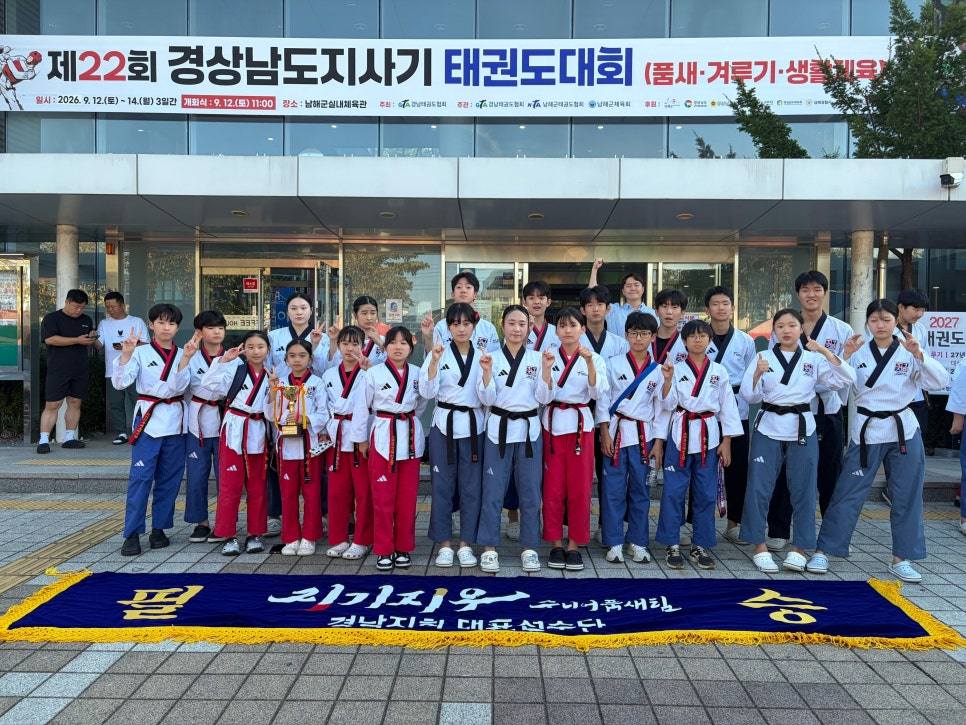 체육관 앞에서 현수막을 펼친 선수단 단체 사진